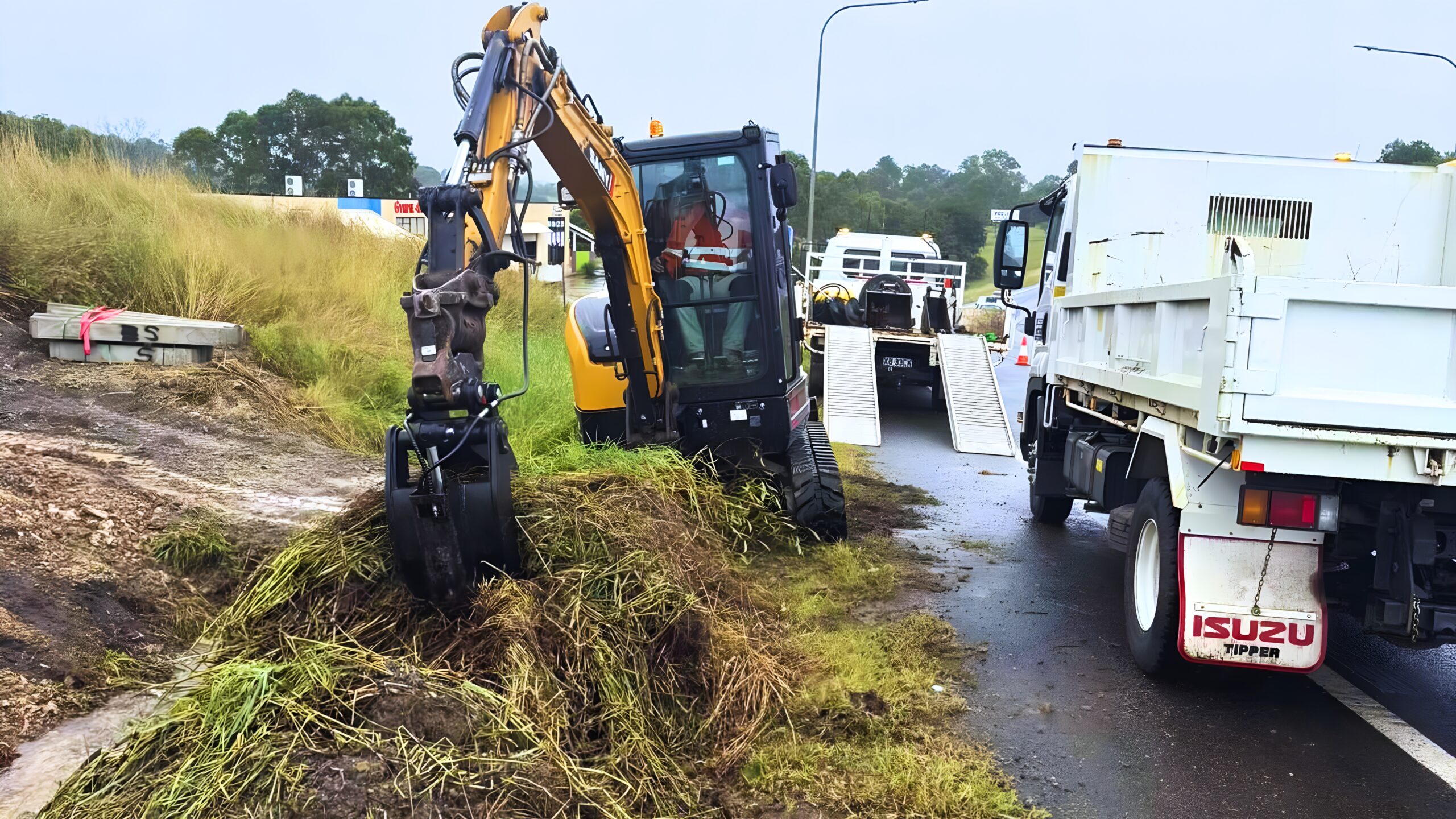 Excavator loading a tipper truck for dirt removal and professional site clean-up services in Bundaberg.